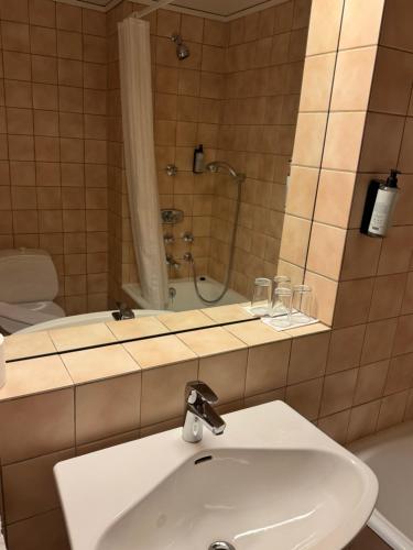 a bathroom with a sink and a shower at Park Hotel Vossevangen in Vossevangen