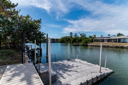 a dock in the water next to a house at Dreamers Hideaway I Waterfront I Direct Access in Naples