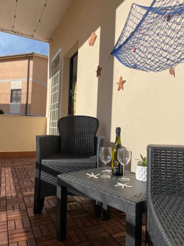 a table with two glasses and a bottle of wine at Alloggio fronte mare Melodia delle Onde in Ladispoli