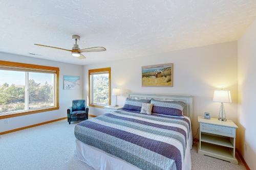 a bedroom with a bed and a chair and a window at KC's Serenity By The Sea in Warrenton
