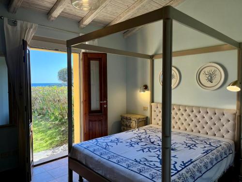 Schlafzimmer mit einem Himmelbett und Meerblick in der Unterkunft Villa Privata Lux con piscina San Teodoro in Porto Ottiolu