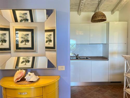 eine Küche mit weißen Schränken und einem gelben Tisch in der Unterkunft Villa Privata Lux con piscina San Teodoro in Porto Ottiolu