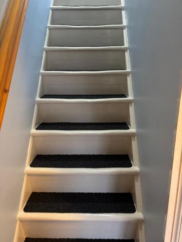 a staircase with white shelves in a room at Traditional 2 bed croft in Portskerra