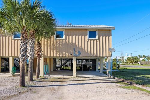 a building with palm trees in front of it at Off The Hook by Pristine Properties Vacation Rentals in Saint Joe Beach