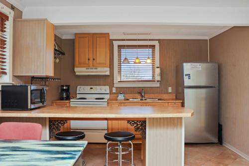 a kitchen with a refrigerator and a counter with stools at Off The Hook by Pristine Properties Vacation Rentals in Saint Joe Beach