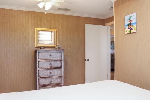 a bedroom with a bed and a dresser and a window at Off The Hook by Pristine Properties Vacation Rentals in Saint Joe Beach