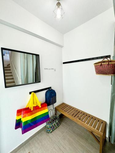une pièce avec un sac arc-en-ciel et un banc dans l'établissement Grand appartement Cosy - Terrasse - 50m de l’océan, à Ploemeur