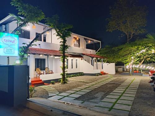 un edificio con un cartello di fronte di notte di Kaswa Beach Resort a Varkala