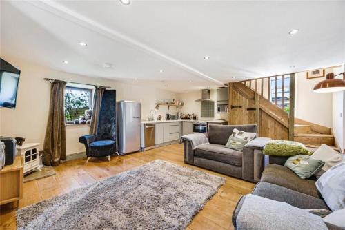 ein Wohnzimmer mit Couch und Küche in der Unterkunft Meagill Cottage Sleeps 4 with Hot Tub & Parking in Otley