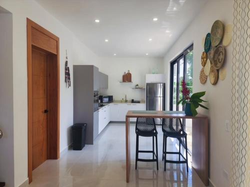 une cuisine avec une table et quelques chaises dans une pièce dans l'établissement Villas Montemar - Villa Sol, à Las Terrenas