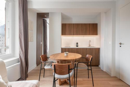 une cuisine et une salle à manger avec une table et des chaises en bois dans l'établissement Casablanca - Gare - CEA - STMicro, à Fontaine