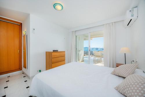 a white bedroom with a bed and a balcony at Can Vidal Des Port de Pollensa in Port de Pollensa