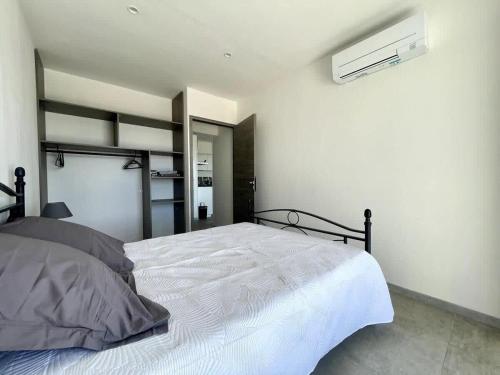 a bedroom with a white bed and a air conditioner at Casamea - Rez de Villa, Famille, Vue mer, Clim2 in Appietto