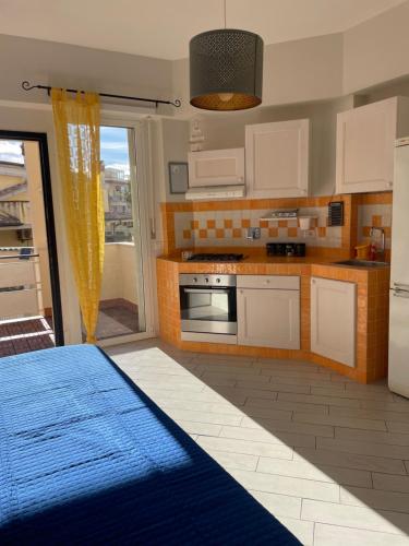 a kitchen with white cabinets and a blue rug at Alloggio fronte mare Melodia delle Onde in Ladispoli