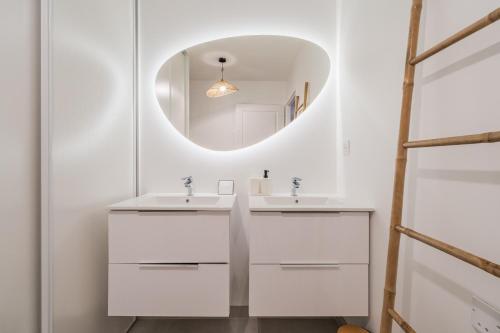 une salle de bain avec deux lavabos et un miroir dans l'établissement T3 Tropical avec parking gratuit, terrasse et wifi, à Toulouse