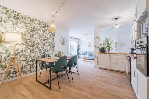 une cuisine et une salle à manger avec une table et des chaises dans l'établissement T3 Tropical avec parking gratuit, terrasse et wifi, à Toulouse