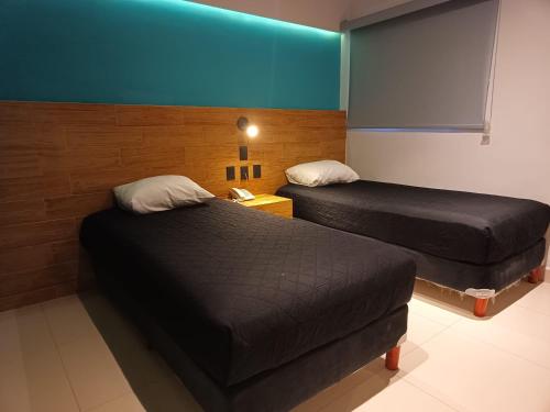 Ένα ή περισσότερα κρεβάτια σε δωμάτιο στο Hotel Kavia Mazatlán