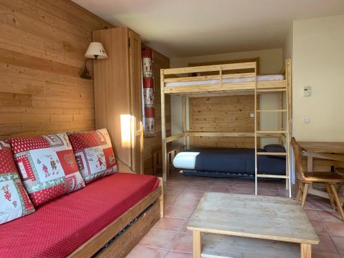 une chambre avec un lit et des lits superposés dans l'établissement Hameau Pra Roustan by Godille, à Pra-Loup