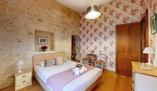 une chambre avec un lit avec un ours en peluche dessus dans l'établissement Les Floralies, Charme médiéval & confort moderne, à Sarlat-la-Canéda