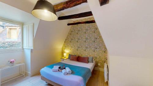 une petite chambre avec un lit et une fenêtre dans l'établissement Les Floralies, Charme médiéval & confort moderne, à Sarlat-la-Canéda