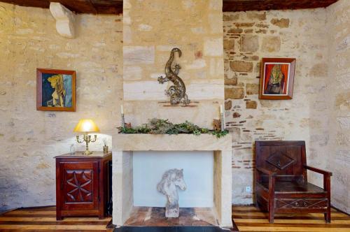- un salon avec une cheminée et un cheval dans l'établissement Les Floralies, Charme médiéval & confort moderne, à Sarlat-la-Canéda