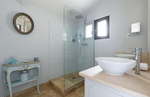 une salle de bain avec un lavabo et une douche en verre dans l'établissement Les Oliviers, à Gordes