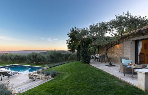 une cour avec une piscine et une terrasse dans l'établissement Les Oliviers, à Gordes