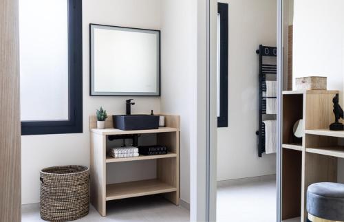 a bathroom with a mirror and a shelf with a sink at Maison de Lauris in Lauris