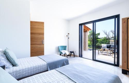 une chambre avec un lit et une porte coulissante en verre dans l'établissement Maison de Villedieu, à Villedieu