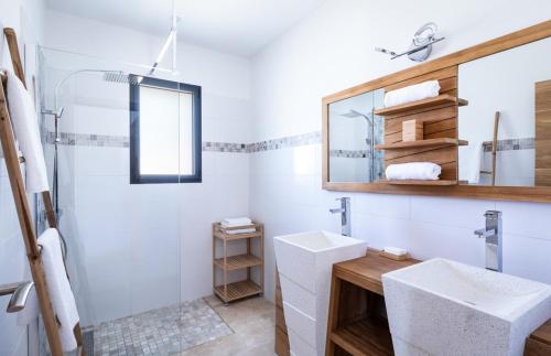 une salle de bain blanche avec un lavabo et un miroir dans l'établissement Maison de Villedieu, à Villedieu