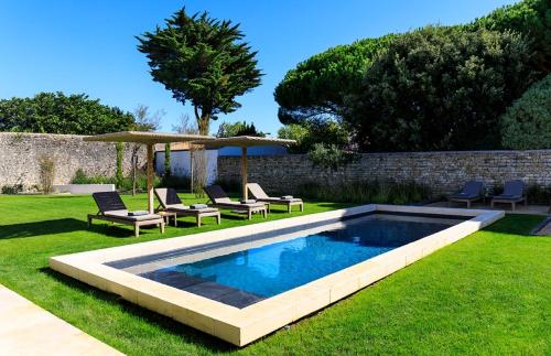 - une piscine dans une cour avec des chaises et un parasol dans l'établissement Le Clos de la Corderie, à La Flotte