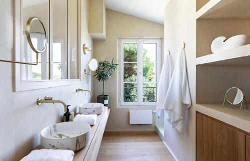 une salle de bain avec deux lavabos et une fenêtre dans l'établissement Le Clos de la Corderie, à La Flotte
