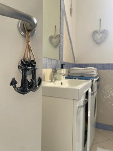 a bathroom with a sink and an anchor on the wall at Alloggio fronte mare Melodia delle Onde in Ladispoli