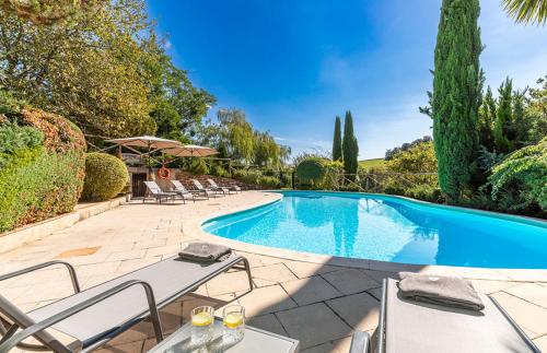 a swimming pool in a yard with chairs and a table at Tarrit de Bas in Castelnau-dʼAuzan