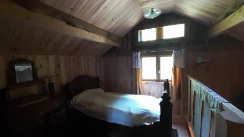 une chambre avec un lit dans une cabane en bois dans l'établissement La Genotte, à La Motte-dʼAveillans
