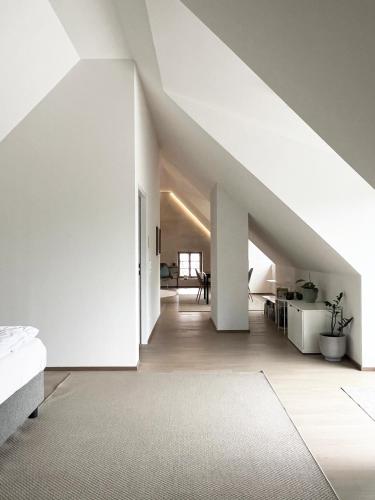 Zimmer im Dachgeschoss mit weißen Wänden und einer Treppe in der Unterkunft Flößerhaus in Steyr