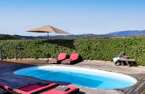 a swimming pool with two chairs and an umbrella at Villa Margaux in Figari
