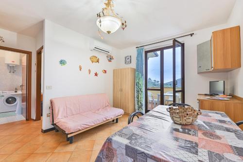 a living room with a table and a pink couch at Colle di Rio - Goelba in Rio nellʼElba