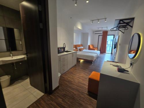 a bathroom with a sink and a living room at K Avenue Kota Kinabalu by Merveille - Sabah in Donggongon