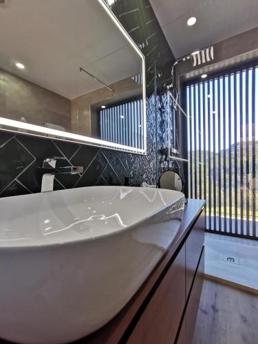 a bathroom with a white tub and a large mirror at Villa Recanto de Fornelos, Gerês - Até 10 Pax in Geres