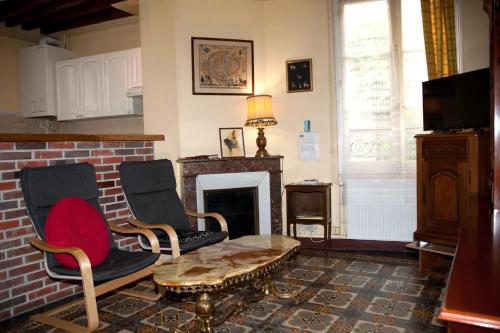 un salon avec deux chaises et une cheminée dans l'établissement Maison accueillante à Auxerre de 50 m² avec jardin, à Auxerre