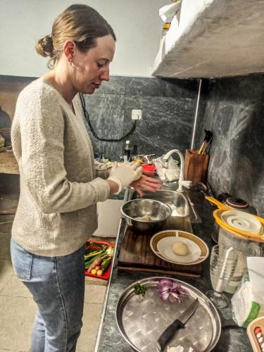 a woman standing in a kitchen preparing food at Creek Downhills in Ella