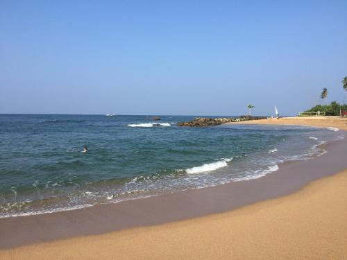 a beach with a person swimming in the ocean at Villa Amorino in Galle