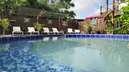 a swimming pool with lounge chairs in a yard at Greenheart Boutique Hotel in Paramaribo