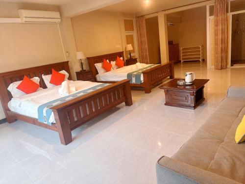 a hotel room with two beds and a couch at Amanda Villa - Best Value Mountain top Inn in Au Cap