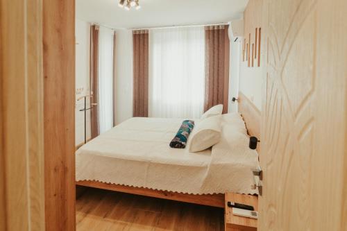 a small bedroom with a bed with white sheets and pillows at Apartment Aria 2 in Velingrad