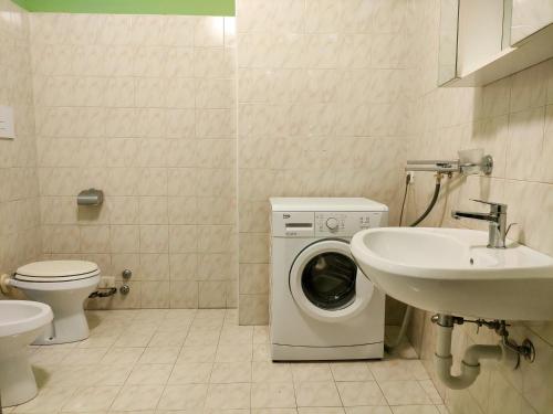 ein Badezimmer mit Waschmaschine und Waschbecken in der Unterkunft Palestro Studio - A Cozy Apartment in Como in Como
