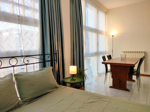 ein Schlafzimmer mit einem Bett, einem Tisch und einem Schreibtisch in der Unterkunft Palestro Studio - A Cozy Apartment in Como in Como