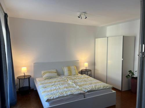 a bedroom with a bed with two night stands and two lamps at Locarno: Casa Lido in Locarno