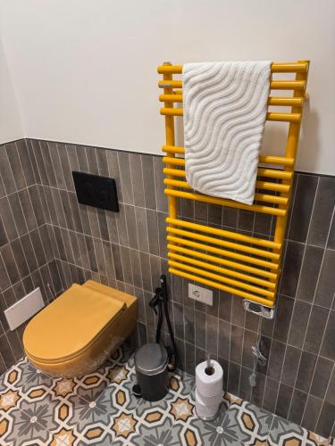 a bathroom with a toilet and a yellow rack with towels at Navona 68 in Rome